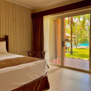 1 dormitorio con 1 cama y puerta corredera de cristal en Hotel Camino Real, en Santa Cruz de la Sierra