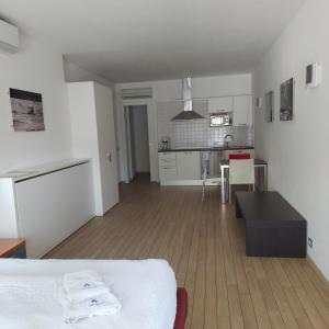 a white room with a bed and a kitchen at Villa Treccani Apartments in Malcesine