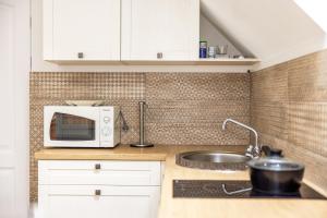 a kitchen with a sink and a microwave at Palanga Deluxe 2 in Palanga