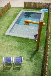 two lounge chairs next to a swimming pool at MILAGRES DO OKA CASA 30 in São Miguel dos Milagres