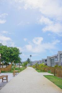 a walkway with benches in a park with buildings at MILAGRES DO OKA CASA 30 in São Miguel dos Milagres +11 photos