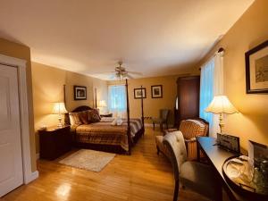 a bedroom with a bed and a living room with a desk at Forest & Lake PEI Bed & Breakfast in Murray Harbour