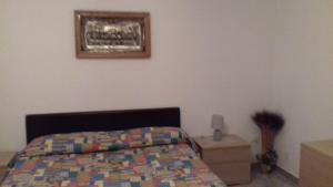 ein Schlafzimmer mit einem Bett und einem Bild an der Wand in der Unterkunft Perla di mare in Montesilvano