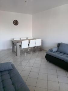 - un salon avec un canapé, une table et des chaises dans l'établissement Appartement 6 places à 200m de l'océan, à La Rochelle