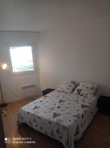 - une chambre avec un lit doté d'une couette et d'une fenêtre dans l'établissement Appartement 6 places à 200m de l'océan, à La Rochelle