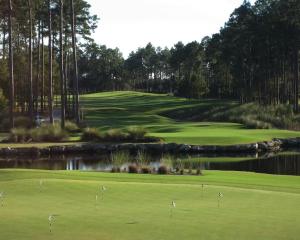 a golf course with a green and a pond at Apartamento Herdade Aroeira, Praia, Golfe perto Lisboa in Almada