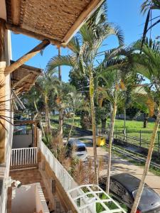 een uitzicht vanaf het balkon van een huis met palmbomen bij Suítes Praia Barequeçaba in São Sebastião