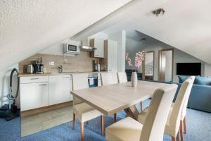 Il comprend une cuisine et une salle à manger avec une table et des chaises en bois. dans l'établissement Haus Susi, à Sautens