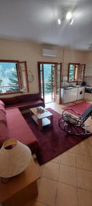 a living room with a couch and a table at 4 Seasons Tzoumerka Life in Melissourgoi