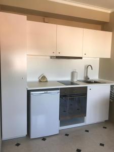 eine Küche mit weißen Schränken, einer Spüle und einem Geschirrspüler in der Unterkunft New Aqueduct View Romantic Apartment in Campolide - 2B in Lissabon