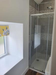 a glass shower in a bathroom with a window at The Stables at Cotton (one mile from Alton Towers) in Oakamoor