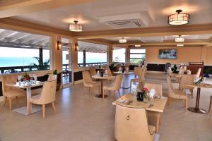 um restaurante com mesas e cadeiras e o oceano em Hotel Grand A View em Montego Bay