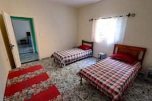 a bedroom with two beds and a mirror at Refúgio de Paz em São Pedro Próximo ao Thermas Water Park in São Pedro