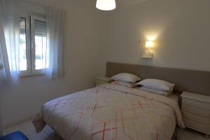 a white bedroom with a large bed and a window at Casinha; Piscina/ Praia/ Lisboa in Aroeira