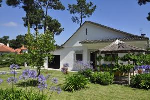 a white house with purple flowers in the yard at Casinha; Piscina/ Praia/ Lisboa in Aroeira