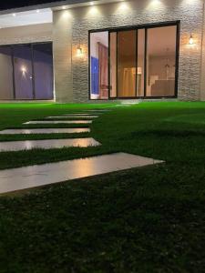 a green lawn in front of a house at night at شاليهات ارينا الفندقية بالطائف in Ash Shuwaybiţ