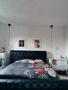 ein Schlafzimmer mit einem schwarzen Bett und einer Blumendecke in der Unterkunft Apartment Stella Danica in Čatež ob Savi