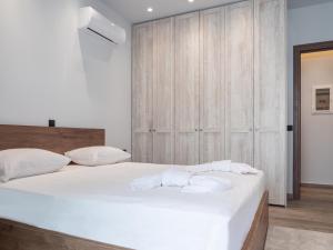 - une chambre avec un grand lit blanc et des serviettes dans l'établissement Apartment Lazarous 3, à Apolakkiá