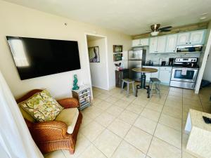 a living room with a flat screen tv on a wall at #808 Gulf View at Lovers Key Beach Club in Fort Myers Beach