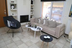 a living room with a couch and a table and chairs at CozyLuxuryApartment in Keramoti
