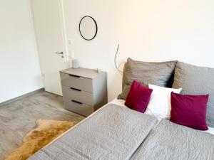 1 dormitorio con 1 cama con almohadas rojas y blancas en Wohnung Alpenblick, en Höchenschwand