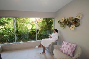a woman sitting in a chair looking out a window at Sugar Bay Barbados - All Inclusive in Bridgetown
