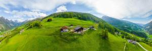 a green hill with a house on top of it at Appartement Seppenbauer in Heiligenblut