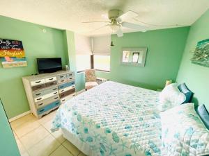 1 dormitorio con 1 cama y vestidor con TV en #808 Lovers Key Beach Club en Fort Myers Beach