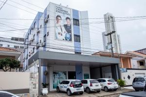 un edificio con coches estacionados frente a él en Hotel Campina Executivo, en Campina Grande