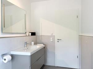 Un baño blanco con lavabo y espejo. en Wohnung Alpenblick, en Höchenschwand 12 fotos más