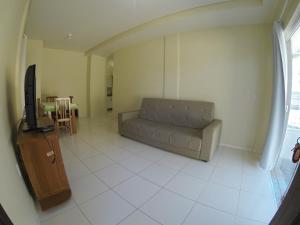 sala de estar con sofá y TV en Apartamentos em Bombas, en Bombinhas