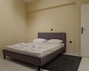 a bed with white sheets and pillows in a room at Apartment Lazarous 2 in Apolakkiá