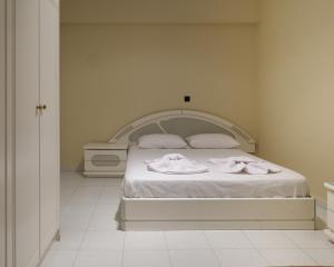 a bedroom with a white bed with towels on it at Apartment Lazarous 2 in Apolakkiá