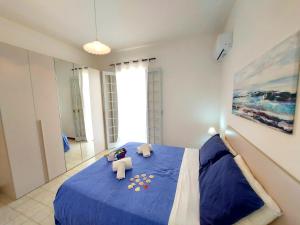 プンタ・セッカにあるCapoSud - Appartamento Giglioのベッドルーム1室(青いベッド1台、動物2匹の詰め物付)