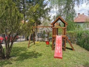 a wooden playground with a slide and a swing set at Vila Breza in Soko Banja