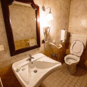 チェラーノにあるHotel Guerrinuccioのバスルーム(洗面台、トイレ、鏡付)