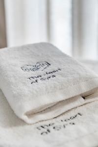 una pila de toallas sentadas encima de una cama en The Heart of Syra - Your Home in Ermoupolis, en Ermoupoli