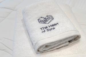 a pile of towels sitting on a bed at The Heart of Syra - Your Home in Ermoupolis in Ermoupoli +100 photos