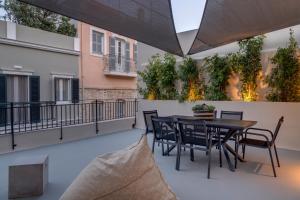 a patio with a table and chairs on a balcony at The Heart of Syra - Your Home in Ermoupolis in Ermoupoli