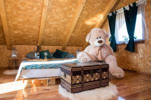 a teddy bear sitting on a chest in a bedroom at Robinzonski smještaj Oaza mira in Končanica