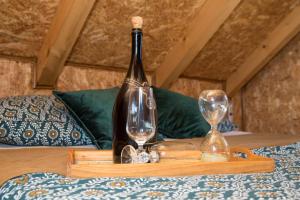 una bottiglia di vino e due bicchieri su un tavolo di Robinzonski smještaj Oaza mira a Končanica
