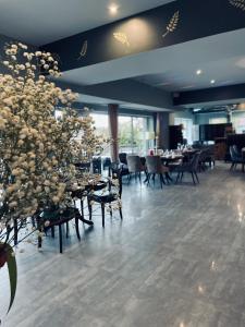 een eetkamer met tafels, stoelen en bloemen bij Laguna House in Līči