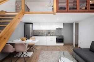 een keuken en woonkamer met een tafel en stoelen bij Palazzine apartments in Pula