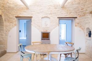 a dining room with a wooden table and chairs at Trullo e Suites Parini 32 in Alberobello