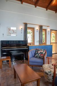 a living room with a blue couch and a piano at Sunray Luxury Apartment Zagora with piano in Zagora