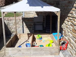 ein hölzerner Sandkasten mit einem weißen Baldachin und Spielzeug darin in der Unterkunft Apartment in Halenfeld near Ski Slope in Sellerich