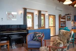 a living room with a piano and chairs at Sunray Luxury Apartment Zagora with piano in Zagora