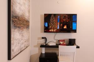 a room with a desk with a television on a wall at Golden Suite Bahai's Garden in Haifa