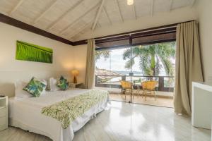 a bedroom with a bed and a large window at Eny Boutique Hotel & Spa in Búzios