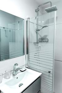 a bathroom with a sink and a shower with a mirror at coral suite new vacation apartment in Eilat